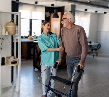 Nurse walks with senior man at home