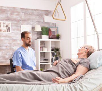Doctor talks to bed bound patient
