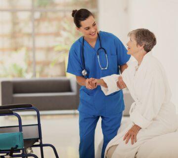 young female caregiver helping senior woman