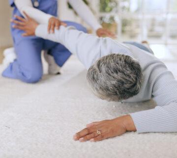Care staff helps senior woman who has fallen